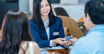 Saleswoman receiving credit card from her client.