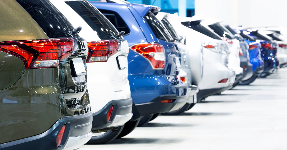 Close-up of a row of urban crossovers for sale inside a car dealership.