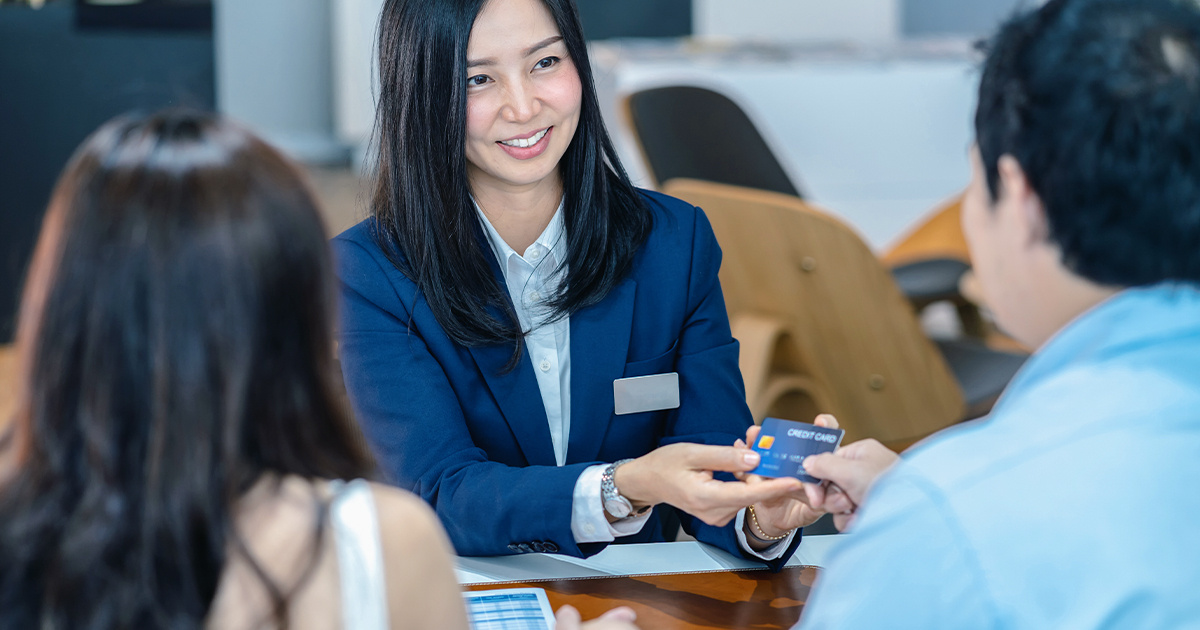 Saleswoman receiving credit card from her client.